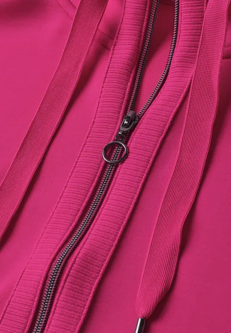 Nahaufnahme eines pinken Stoffs mit rundem Reißverschluss-Zipper und vertikalen Ziernähten.