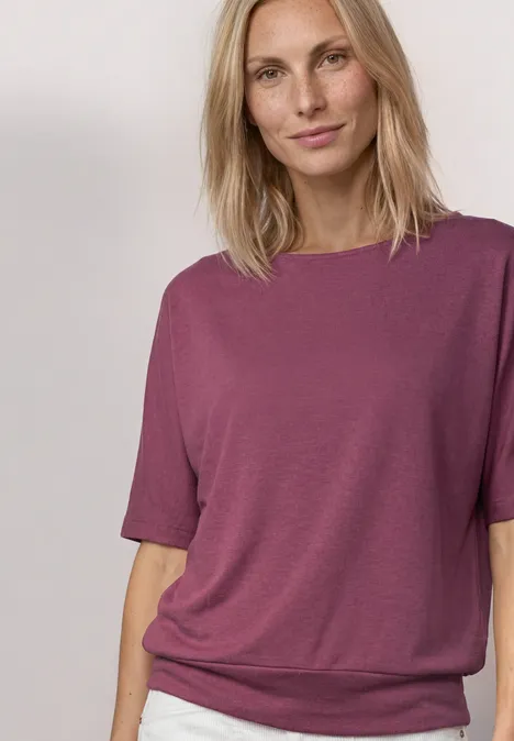 Basic Shirt met boothals en elastische zoom dark clouded blush Iemand draagt een losse pruimkleurige T-shirt met korte mouwen, voor een lichte achtergrond.
