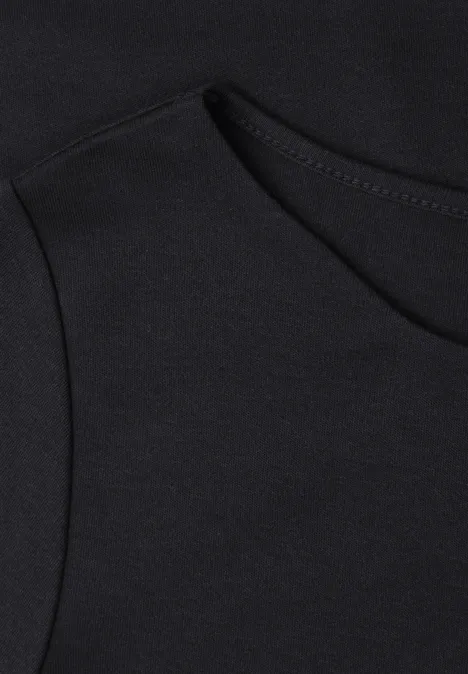 Gros plan sur un tissu noir de vêtement avec une poche discrète et des coutures soignées.
