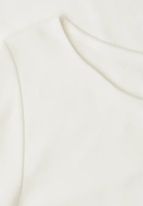 Shirt met golvende halslijn in effen kleur off white Close-up van een wit T-shirt met ronde hals op een lichte achtergrond.