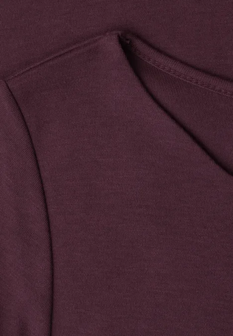 Nahaufnahme eines bordeauxroten Sweatshirts mit Taschennaht