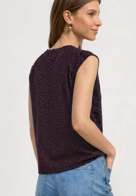 Shirt mit Boat Neck und Elastikbund rustic rouge Raglan-Oberteil ohne Ärmel mit dezentem Leopardenmuster in Dunkellila, kombiniert mit hellblauen Jeans.
