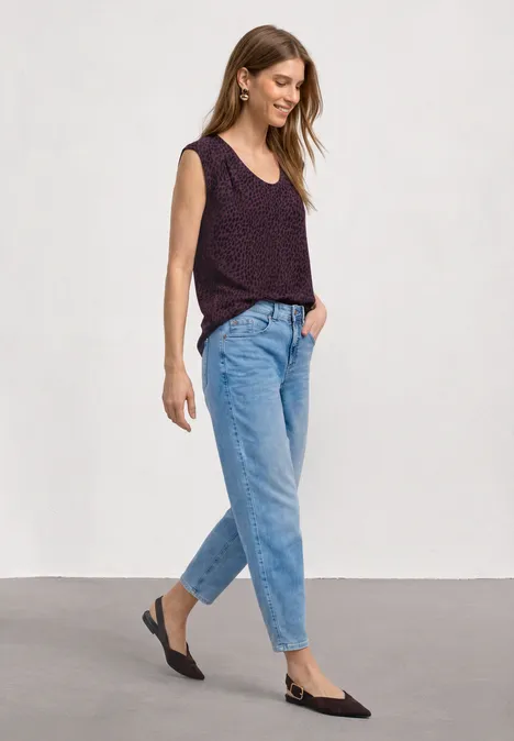 Shirt mit Boat Neck und Elastikbund rustic rouge Frau in violettem Ärmellosem Strickoberteil, blauen Jeans und schwarzen Slingback-Schuhen auf weißem Hintergrund.