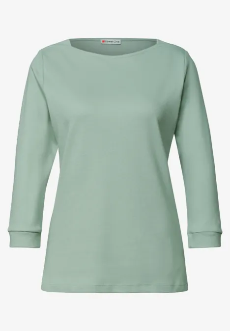 Sanftgrünes Langarmshirt mit klassischem Rundhalsausschnitt, schmaler Passform und Bündchen an den Ärmeln.