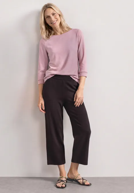 3/4-Arm Shirt mit U-Boot-Ausschnitt quiet rose Eine Frau trägt rosa Langarmshirt, schwarze weite 7/8-Hose und schwarze Sandalen vor hellem Hintergrund.