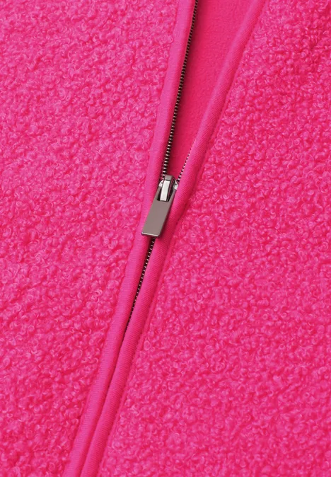 Nahaufnahme eines leuchtend pinken Reißverschlusses auf flauschigem Fleece-Stoff.
