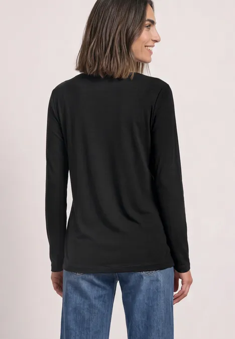 Basic Shirt mit U-Boot-Ausschnitt Black Frau von hinten in schwarzem Langarmshirt und blauen Jeans, schulterlanges Haar, lächelt seitlich