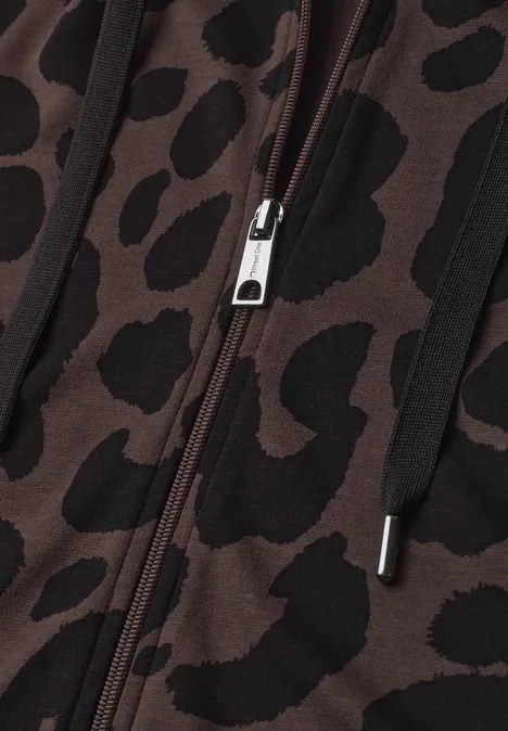 Weste mit Kapuze und Print molten earth Nahaufnahme eines Reißverschlusses an einem braunen Kleidungsstück mit Leopardenmuster.