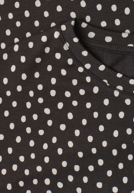 Schwarzes Kleidungsstück mit weißem Polka-Dot-Muster.