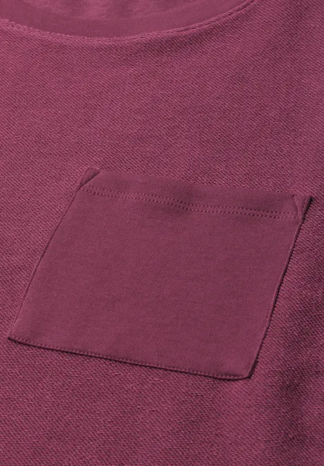 Un t-shirt violet uni avec poche plaquée sur la poitrine.