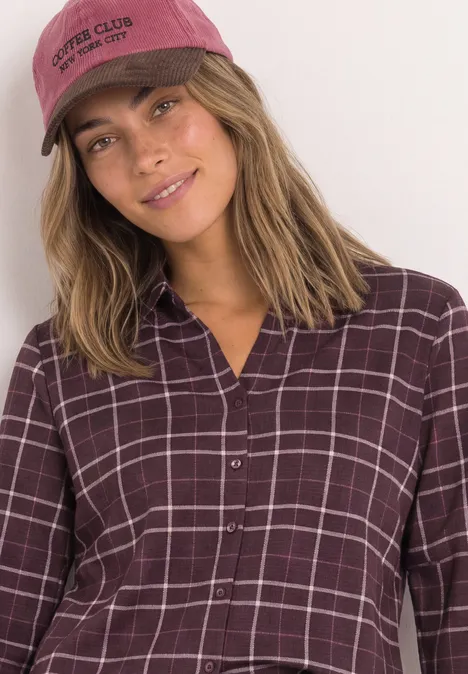 3/4-Arm Shirt aus Jersey im Blusen-Look rustic rouge Eine lächelnde junge Frau mit blonden Haaren trägt eine bordeauxrote Kappe und ein kariertes Hemd.