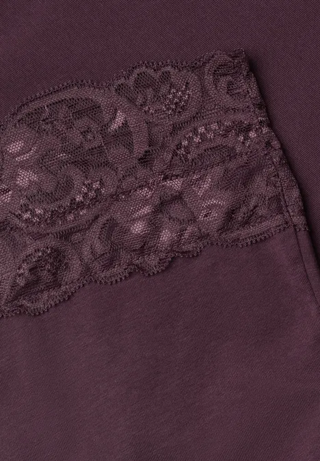 Nahaufnahme eines violetten Stoffes mit zarter Spitzenborte.