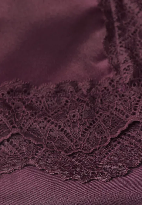 Close-up van bordeaux satijn met gebloemde kant