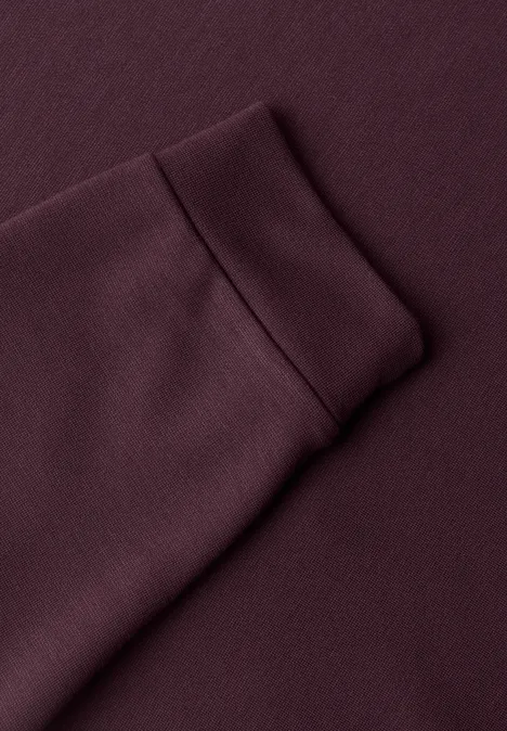 Nahaufnahme eines burgunderroten Sweatshirt-Ärmels mit Rippbündchen