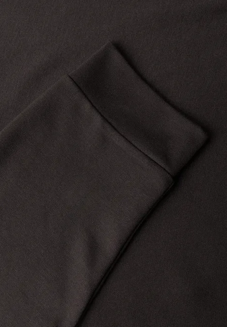 Schwarzer Stoff mit aufgesetzter Tasche und Bündchen, vermutlich ein Sweatshirt.