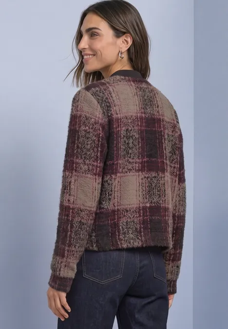 Vrouw gezien van achteren met een gebreid ruitpatroon vest in bordeaux en beige, casual stijl.