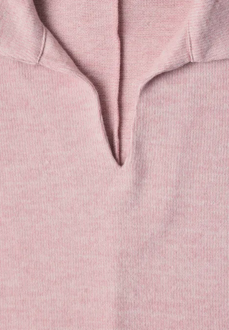 Nahaufnahme eines rosa Strickpullovers mit V-förmigem Ausschnitt und weicher Struktur.