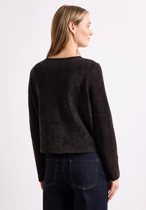 Jas met lange mouwen, ronde hals en knopen black coffee Frau von hinten im dunklen, langärmligen Pullover und Jeans vor weißem Hintergrund.