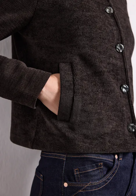 Jas met lange mouwen, ronde hals en knopen black coffee Dunkelbraune Jacke mit Knöpfen, Hand in der seitlichen Tasche, dazu blaue Jeans.