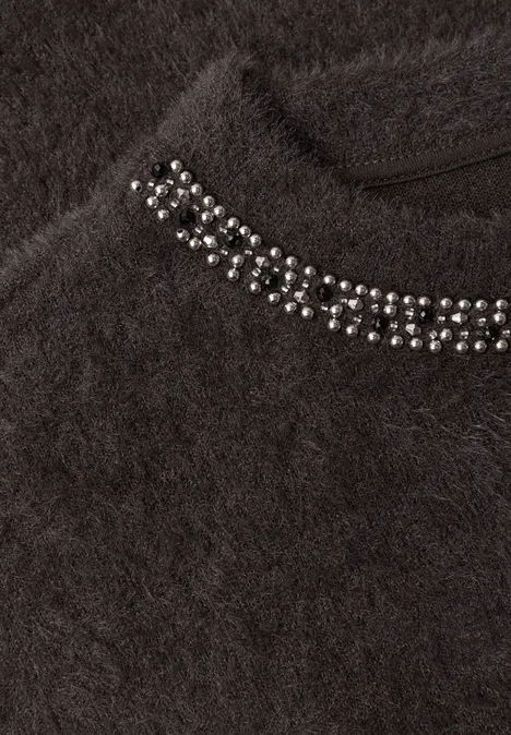 Dunkler, flauschiger Pullover mit silbernen Nieten am Kragen.