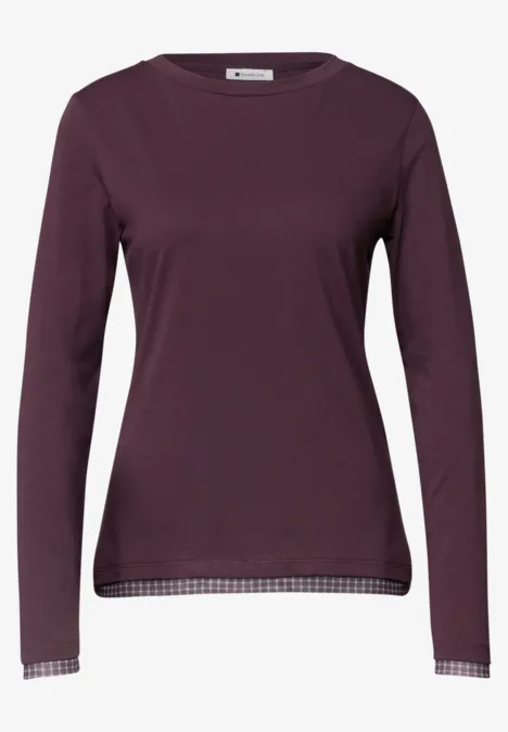 Damen-Langarmshirt in dunklem Lila mit Rundhalsausschnitt und Karomuster an Saum und Bündchen.