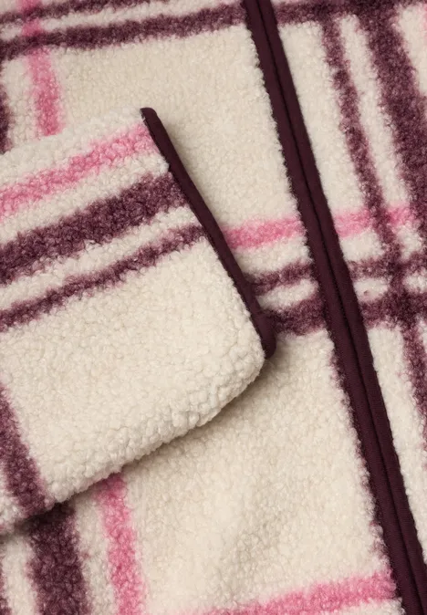Zachte crème teddyfleece met bordeaux-roze ruitenpatroon en ritssluiting.