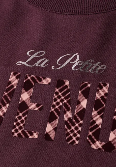 Bordeauxroter Pullover mit der Aufschrift 'La Petite VENUE', das Wort 'VENUE' ist kariert