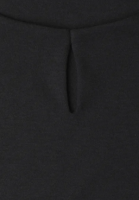 Shirt met afhangende schouders en uitsnijding Black Close-up van een zwarte stof met kleine druppelvormige uitsnijding bij de hals