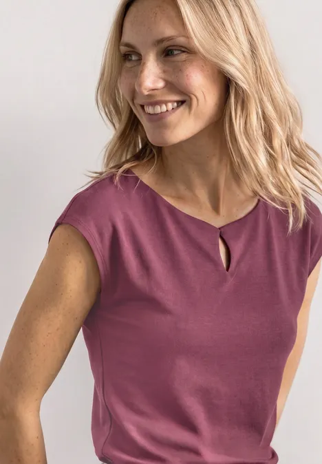 Shirt met afhangende schouders en uitsnijding dark clouded blush Vrouw met blond haar draagt een mouwloos rosé topje voor een witte achtergrond.