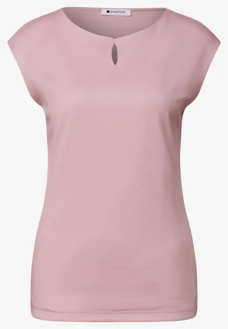 Un débardeur femme rose pâle à encolure ronde avec petite ouverture.