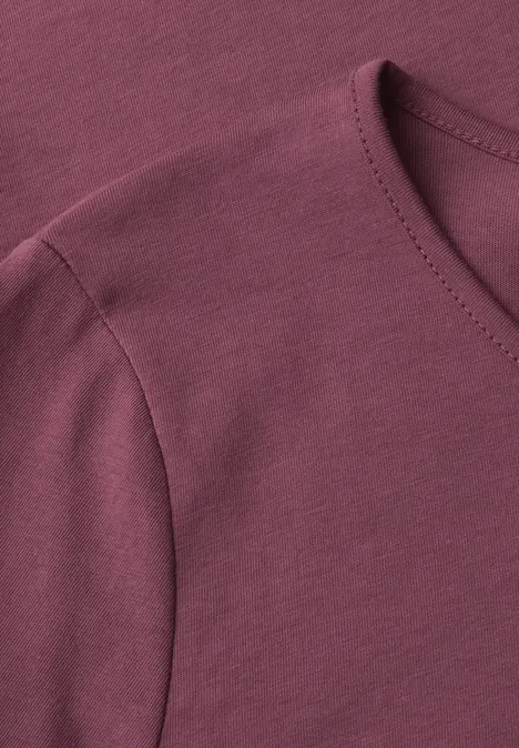 Nahaufnahme eines bordeauxroten T-Shirts mit Rundhalsausschnitt und Schulternaht.