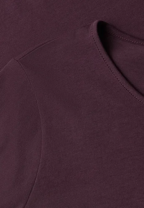T-shirt basique à manches longues, couleur unie rustic rouge Gros plan d'un t-shirt violet foncé, mettant en valeur l'encolure et les coutures.