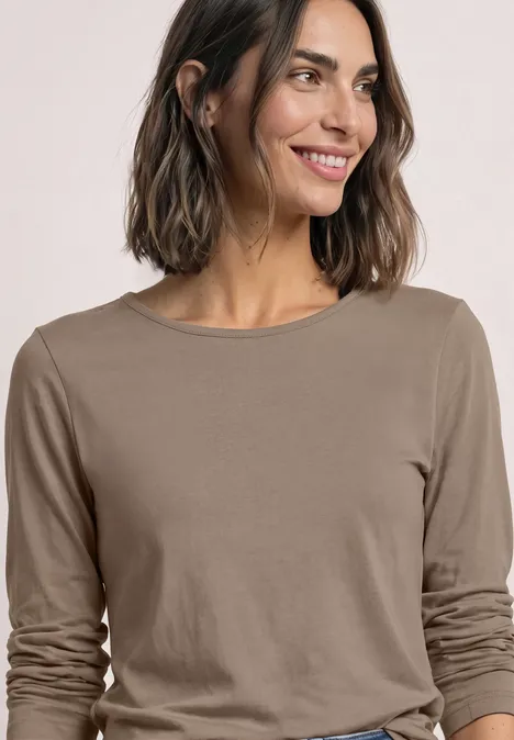 Basic Langarm Shirt in Unifarbe sanded amber Eine lächelnde Frau in einem taupefarbenen Langarmshirt vor hellem Hintergrund