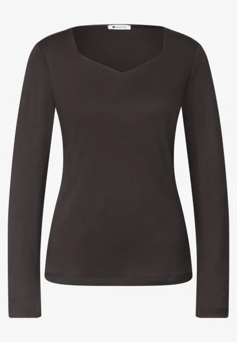 T-shirt noir moulant à manches longues avec un col en cœur discret.