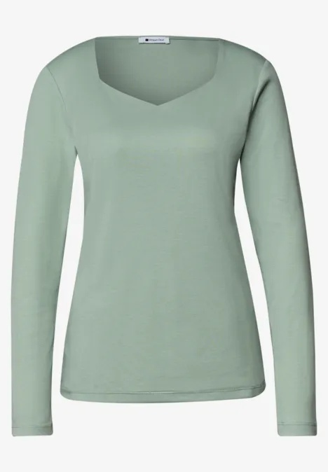 Un t-shirt vert clair à manches longues avec encolure en forme de cœur