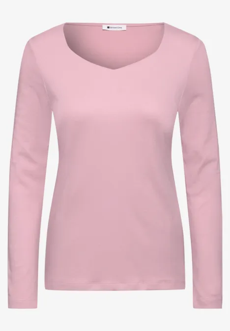Een eenvoudig damesshirt in roze met lange mouwen en ronde hals.