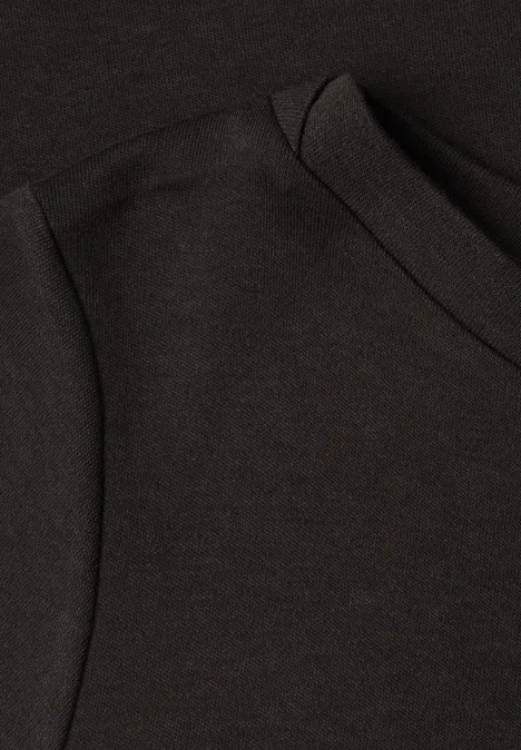 Nahaufnahme eines schwarzen T-Shirts mit Schulter- und Kragennaht.