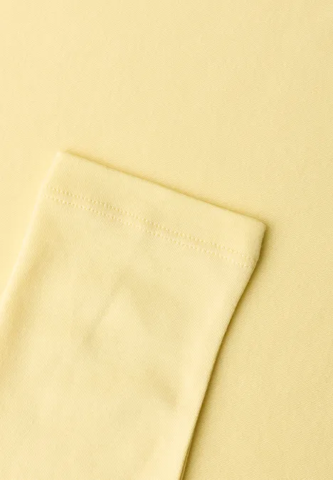 Close-up van een lichtgeel stuk stof met een zichtbare naad