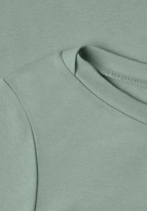 Nahaufnahme eines hellgrünen T-Shirts mit rundem Halsausschnitt.