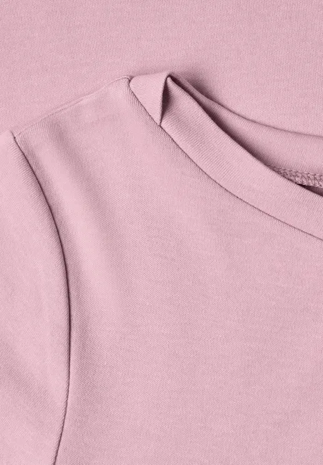 Nahaufnahme eines pastellrosa T-Shirts mit Rundhalsausschnitt aus weichem Baumwollstoff.