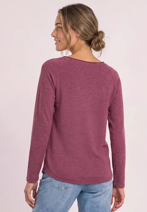 Langarm Shirt mit Rundhals und Rollkante dark clouded blush Frau von hinten in einem langärmligen bordeauxroten Pullover und blauen Jeans.
