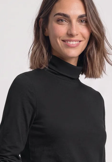 Langarm Shirt in Unifarbe mit Rollkragen Black Porträt einer lächelnden Frau mit braunen Haaren, die einen schwarzen Rollkragenpullover trägt.