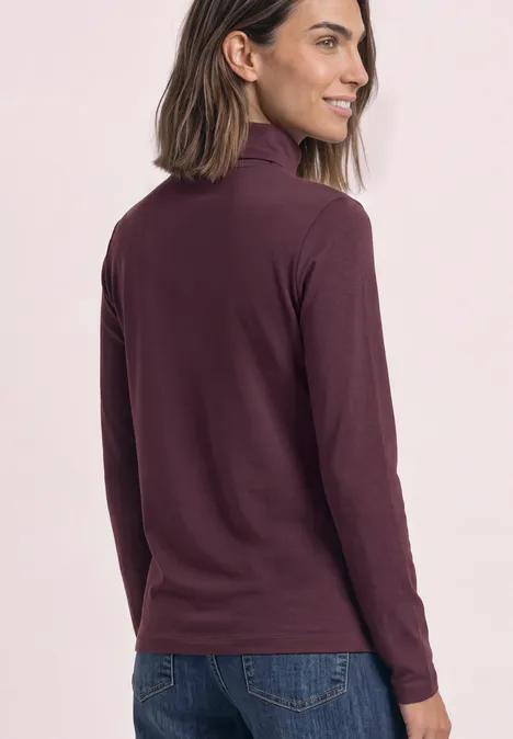 T-shirt à manches longues uni à col roulé rustic rouge Femme en pull col roulé prune et jean, vue de profil et de dos.