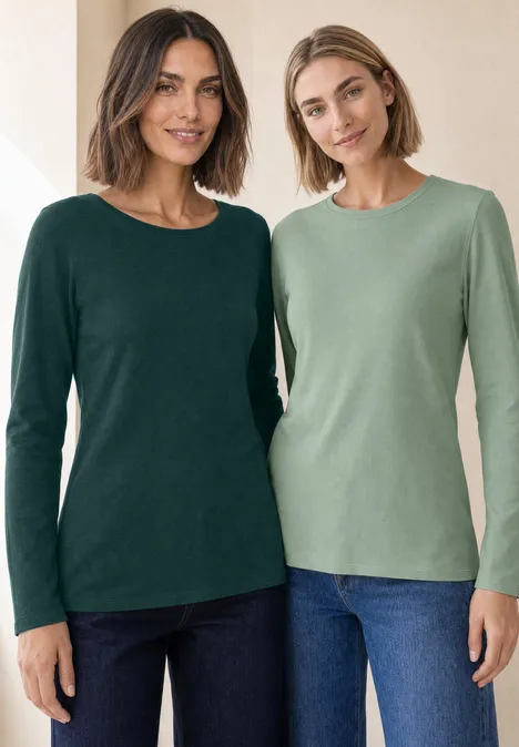 Langarm Shirts mit Rundhals im 2er-Pack shadow teal/eucalyptus green Zwei Frauen tragen langärmelige, grüne Shirts und Jeans, lächeln in heller Umgebung.