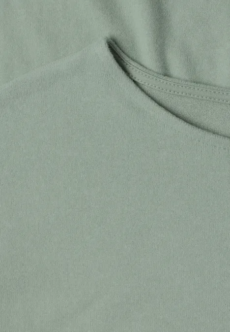 Nahaufnahme eines hellgrünen T-Shirts mit Rundhalsausschnitt und feiner Stoffstruktur.