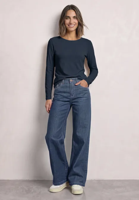 Lot de 2 t-shirts à manches longues et encolure bateau darkest blue/clay sand Eine Frau trägt ein langärmeliges dunkelblaues Shirt, weite Jeans und weiße Sneaker vor hellem Hintergrund.