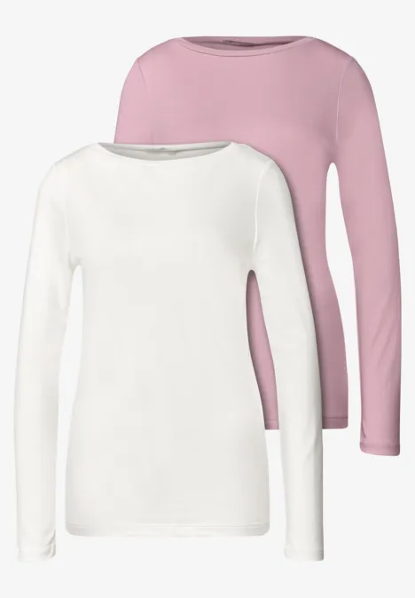 Zwei schlichte Langarmshirts in Weiß und Rosa mit rundem Ausschnitt.