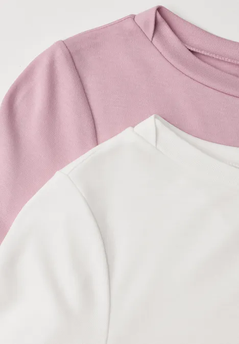 Zwei übereinandergelegte T-Shirts in Weiß und Rosa, Nahaufnahme von Schulter- und Kragenbereich.