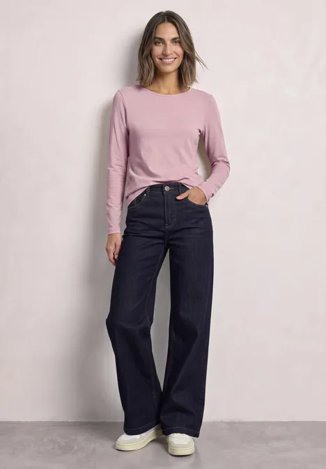 Lot de 2 t-shirts à manches longues et col bateau off white/quiet rose Eine Frau trägt ein rosafarbenes Langarmshirt und weite dunkelblaue Jeans vor hellem Hintergrund.