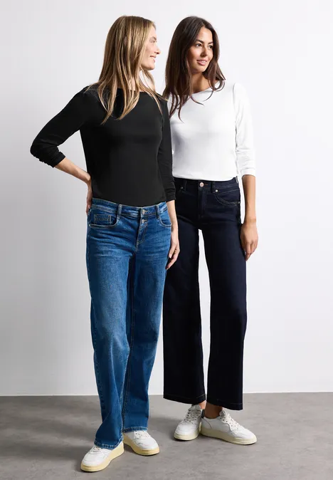 Shirts met lange mouwen en boothals, in een set van 2 stuks white/black Zwei junge Frauen stehen nebeneinander, tragen lässige Jeans, langärmlige Oberteile und weiße Sneaker.